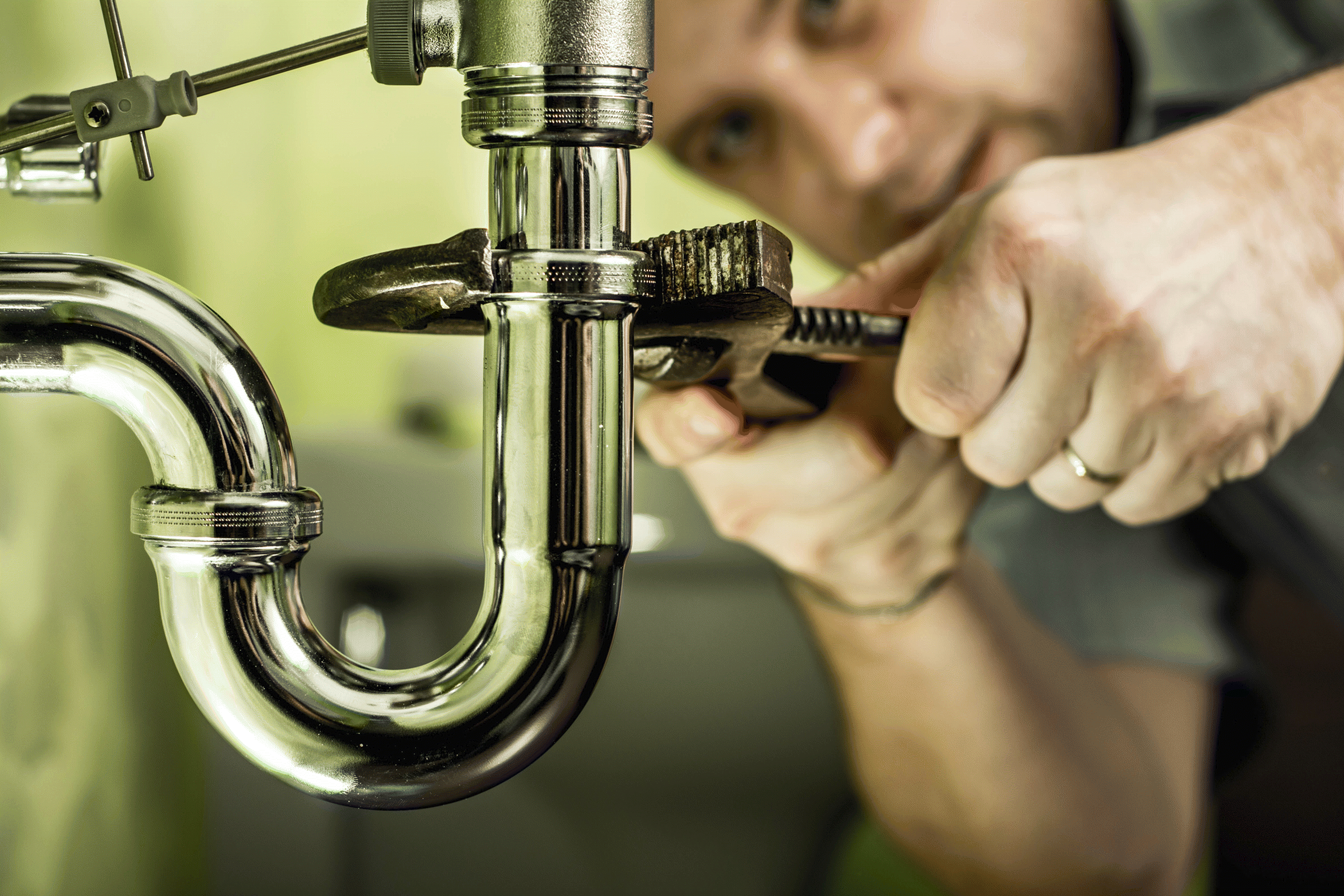 Example photo of a plumber fixing a leaking pipe